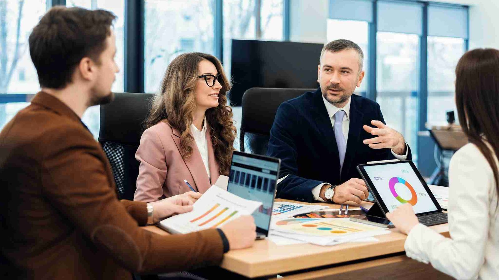 Professionals discussing business strategy and performance analytics during a corporate meeting, highlighting key concepts in business management.